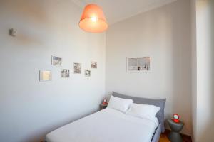 a white bedroom with a bed and a lamp at Fontana Più Stella in Rome