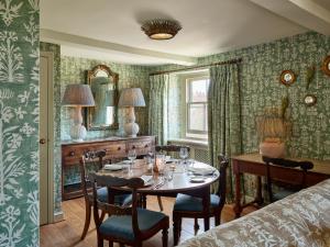 a dining room with a table and chairs and a mirror at Townhouse Suites- Abbey Row in Malmesbury
