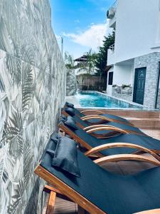 a group of chairs sitting next to a swimming pool at Ilio Boutique Hotel in Ksamil