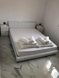 a white bed with towels on it in a bedroom at Alex Apartments Skiathos in Skiathos