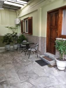 a patio with a table and chairs and plants at Linda's house 2 in Agria