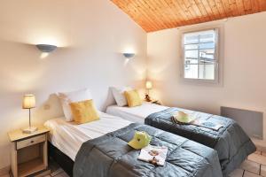 1 dormitorio con 2 camas y ventana en Camping Le Petit Rocher, en Longeville-sur-Mer