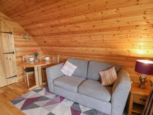 a living room with a couch and a table at Pine Lodge in Llangadog