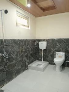 uma casa de banho com um WC e uma janela em Chogho-Sar Huts em Ponedas