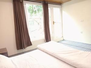 um quarto com uma cama e uma grande janela em Chogho-Sar Huts em Ponedas