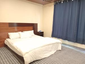 um quarto com uma cama grande e uma cortina azul em Chogho-Sar Huts em Ponedas