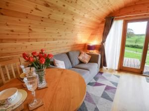 a living room with a couch and a table with flowers at Pine Lodge in Llangadog
