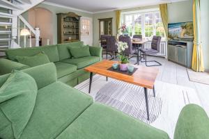 a living room with green couches and a table at Inselperle im Horsatal Inselperle im Horsatal in Wenningstedt