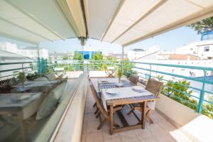Un balcón con una mesa y sillas en un tejado. en Luxury Suites Collection - Pascoli 13, en Riccione