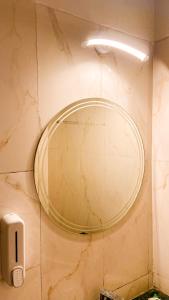 a round mirror on a wall in a bathroom at AASHIYANA HOMESTEAD DLF My Pad in Lucknow