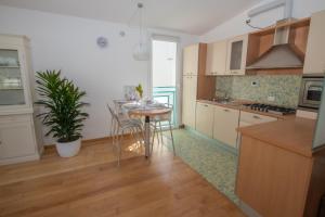 Una cocina con una mesa y sillas en una habitación. en Luxury Suites Collection - Pascoli 13, en Riccione 9 fotos más