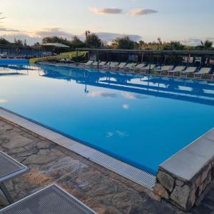 una gran piscina con sillas y agua azul en B&B Casa Vacanze Stella Di Mare en Battipaglia