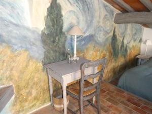 une table dans une pièce ornée d'une peinture murale dans l'établissement Le Jas des aiguiers, à Saint-Saturnin-lès-Apt