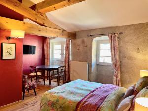 a bedroom with a bed and a table and chairs at LE CLOS D'ALET in Alet-les-Bains