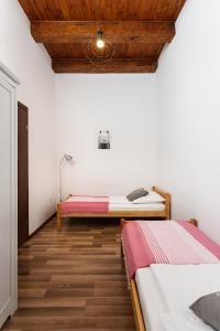 a bedroom with two beds and a wooden ceiling at City of the Kings-Camomile Apartment in Krakow