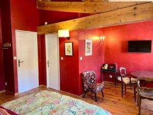 a room with red walls and a table and chairs at LE CLOS D'ALET in Alet-les-Bains