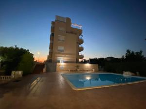 a hotel with a swimming pool in front of a building at XimoApartments AP-6 ÁTICO DUPLEX CON VISTAS AL MAR Y PISCINA in Oliva