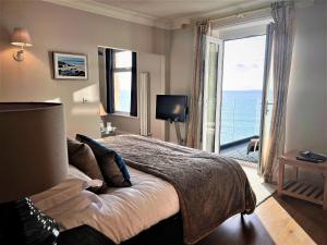 a bedroom with a bed with a view of the ocean at Watersmeet Hotel in Woolacombe