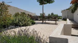 un parque con un banco y una mesa en un jardín en 'Au Coeur des Vignes' - private apartment & garden en Magalas