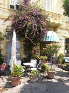 a patio with a table and chairs and flowers at Hotel Miramare in Lavagna