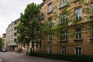 a large brick building with a tree in front of it at City of the Kings-Camomile Apartment in Krakow