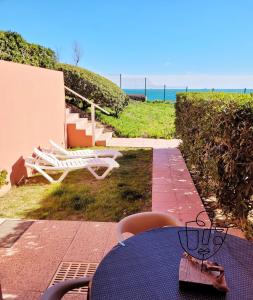 une table et des chaises bleues avec vue sur l'océan dans l'établissement Cosy T2 refait à neuf climatisé, vue mer avec terrasse et jardin, Wifi piscine tennis et parking, à Sète
