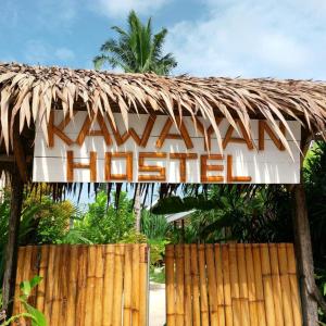 ein Schild für ein hawaiianisches Hotel auf einem Holzzaun in der Unterkunft Kawayan Hostel in General Luna