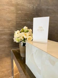 a vase of flowers on a counter with a box at Atrium Deluxe Resort in Golem