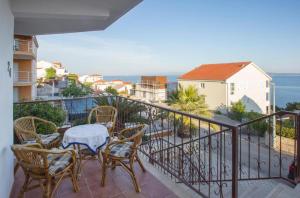 a balcony with a table and chairs and the ocean at Serenity near the sea in Okrug Gornji