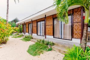 ein Haus am Strand mit Palmen in der Unterkunft Kawayan Hostel in General Luna