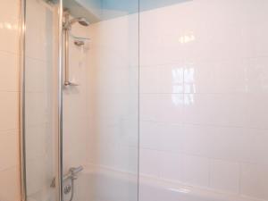 a bathroom with a shower with a glass door at Pixie Cottage in Weymouth