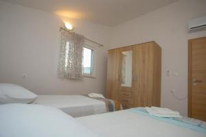 a hotel room with two beds and a window at Serenity near the sea in Okrug Gornji