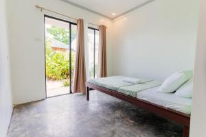 a bedroom with a bed and a large window at Kawayan Hostel in General Luna