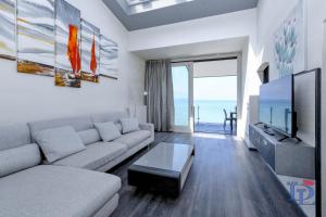 ein Wohnzimmer mit einem Sofa und einem Flachbild-TV in der Unterkunft DesenzanoLoft Villa Meraviglia in Desenzano del Garda