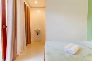 Una habitación con una cama con dos toallas. en Kawayan Hostel, en General Luna