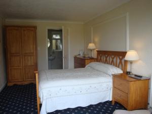 a bedroom with a bed and two lamps and a bathroom at Groeslon Ty Mawr B & B in Llanddeiniolen