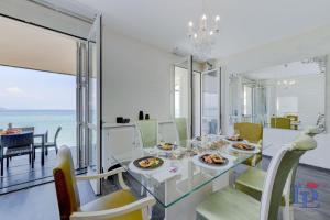 ein Esszimmer mit einem Tisch, Stühlen und Meerblick in der Unterkunft DesenzanoLoft Villa Meraviglia in Desenzano del Garda