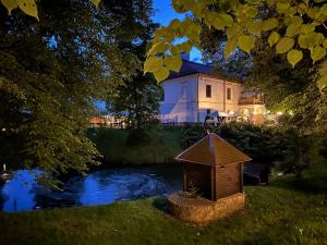 a house with a bird house in front of a pond at Zamek Dubiecko in Dubiecko