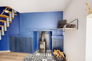 um quarto com uma parede azul e um fogão em La Source d'Eugénie Vue Panoramique au Bugue em Le Bugue