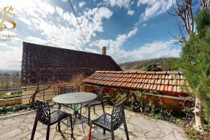 un patio avec une table et des chaises et un bâtiment dans l'établissement La Source d'Eugénie Vue Panoramique au Bugue, au Bugue