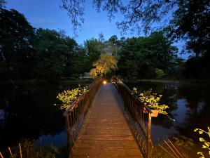 un puente de madera sobre un lago por la noche en Zamek Dubiecko, en Dubiecko