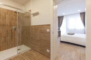 een badkamer met een douche en een bed in een kamer bij Alle Arce in Domegge di Cadore