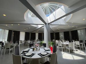 a dining room with tables and chairs and a large window at Atrium Deluxe Resort in Golem
