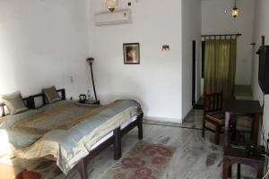 1 dormitorio con cama, escritorio y silla en Royal Farm Bharatpur, en Bharatpur