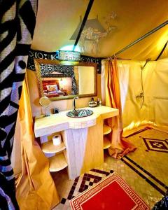 a bathroom with a sink and a mirror in a tent at Merzouga dreams Camp in Erfoud