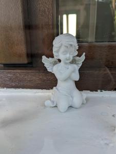 a white statue of a cherub sitting on the ground at Lake House Anemona in Buhalniţa