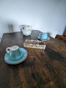 einem Holztisch mit zwei Tassen und Tellern darauf in der Unterkunft Lake House Anemona in Buhalniţa
