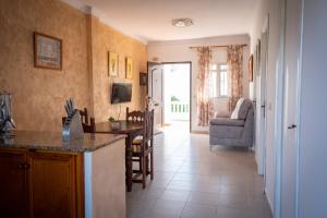 a kitchen and living room with a table and a couch at Apartamentos Turísticos Cabo Roche in Conil de la Frontera