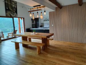 una sala da pranzo con tavolo in legno e panca di Les GITES DE CAMPARAN - gîte "le GRAND CHALET AVEC SPA ET SAUNA" a Camparan