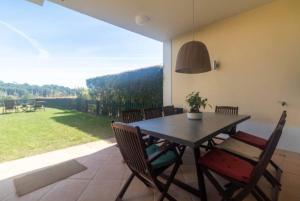 ein Esszimmer mit einem Tisch, Stühlen und einem Fenster in der Unterkunft Quinta Formosa - Villas in Quinta do Lago
